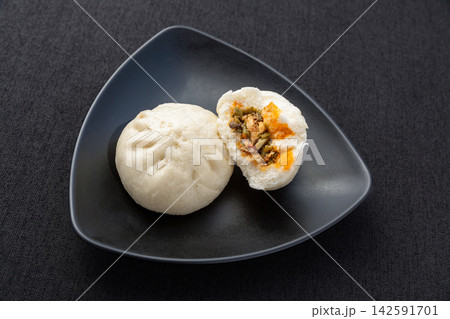steamed pork and pickled cowpea sour beans buns on black plate, authentic Chinese savory baozi steamed pork and pickled cowpea sour beans buns on black plate, authentic Chinese savory baozi 142591701