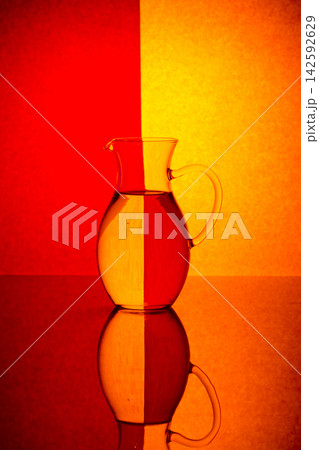 Glass decanter with clean water on a colored background Glass decanter with clean water on a colored background 142592629