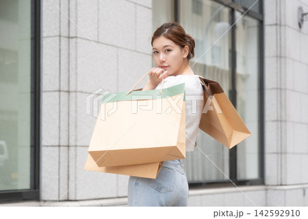 買い物を楽しむおしゃれな若い女性のポートレート 買い物を楽しむおしゃれな若い女性のポートレート 142592910