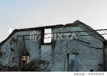 Dilapidated abandoned house with collapsed roof and tangled overhead wires Dilapidated abandoned house with collapsed roof and tangled overhead wires 142593203