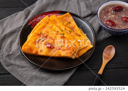 crispy Chinese sesame paste flatbread slices brushed with savory spicy sauce and green onions. crispy Chinese sesame paste flatbread slices brushed with savory spicy sauce and green onions. 142593524