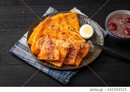 crispy Chinese sesame paste flatbread slices brushed with savory spicy sauce and green onions. crispy Chinese sesame paste flatbread slices brushed with savory spicy sauce and green onions. 142593525