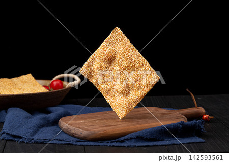 henan style crispy square sesame flatbread tile crackers on black ceramic plate 142593561