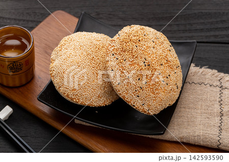 crispy Chinese hollow sesame flatbread, traditional baked pastry pocket on a plate. crispy Chinese hollow sesame flatbread, traditional baked pastry pocket on a plate. 142593590