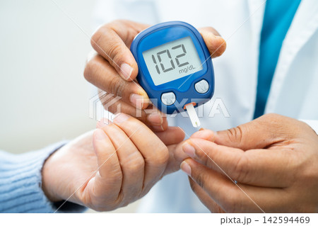 Doctor check diabetes from finger blood sugar level with finger lancet. Doctor check diabetes from finger blood sugar level with finger lancet. 142594469