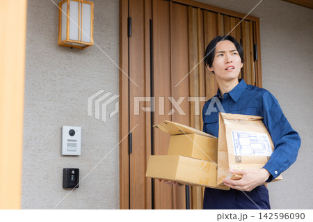 荷物を届ける男性ドライバー 荷物を届ける男性ドライバー 142596090