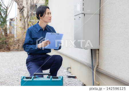 住宅設備を点検する作業服の男性 住宅設備を点検する作業服の男性 142596125