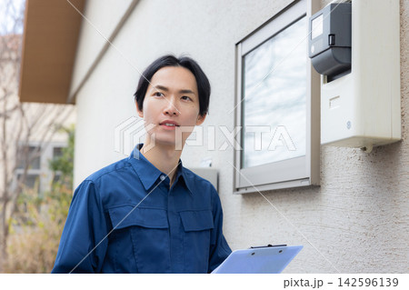 住宅設備を点検する作業服の男性 142596139