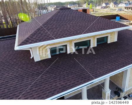 Bituminous tile for a roof. House with a roof from a bituminous 142596449