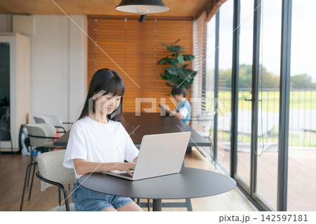 カフェでパソコンを使っている小学生女子 カフェでパソコンを使っている小学生女子 142597181
