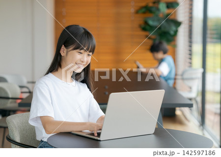 カフェでパソコンを使っている小学生女子 カフェでパソコンを使っている小学生女子 142597186