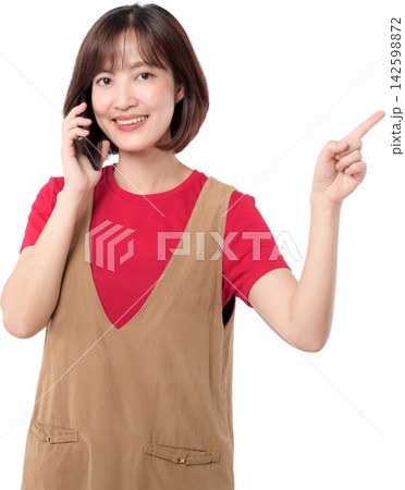 Asian woman holding smartphone and pointing upward with cheerful expression isolated on transparent background 142598872