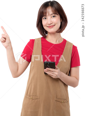 Asian woman holding smartphone and pointing upward with friendly smile isolated on transparent background 142598873