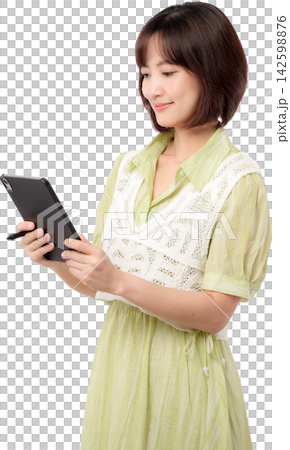 Asian woman using tablet in light green dress with gentle smile isolated on transparent background 142598876