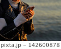 海辺でスマートフォンを操作する女性 142600878