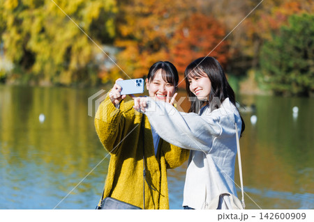 水辺に立って自撮りする若い女性 秋の紅葉 水辺に立って自撮りする若い女性 秋の紅葉 142600909