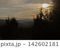 Sunset over forested mountains with silhouettes of pine trees 142602181