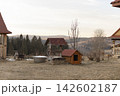 Wooden well and small dog house in rural mountain landscape 142602187