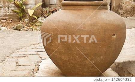 Traditional Clay Water Jar Outside a Rustic Village Alley 142604353