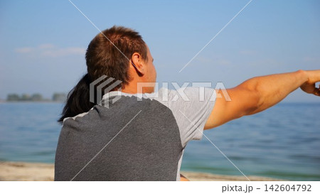 Happy pair hugs during sitting on wooden log on beach. Romantic couple admiring sea landscape at sunny day. Lovers spending time together at resort. Concept of summer vacation or holiday. Slow mo Happy pair hugs during sitting on wooden log on beach. Romantic couple admiring sea landscape at sunny day. Lovers spending time together at resort. Concept of summer vacation or holiday. Slow mo 142604792