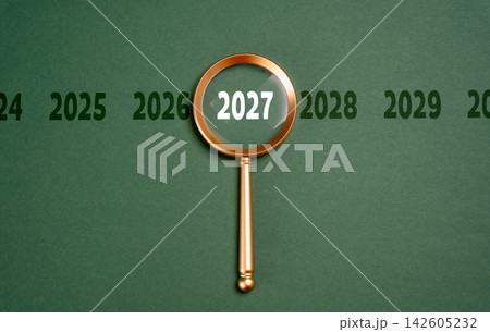 Year 2027 in focus of magnifying glass, future forecast concept. Looking ahead supports business planning, economic analysis and strategic decisions about opportunities, risks Year 2027 in focus of magnifying glass, future forecast concept. Looking ahead supports business planning, economic analysis and strategic decisions about opportunities, risks 142605232