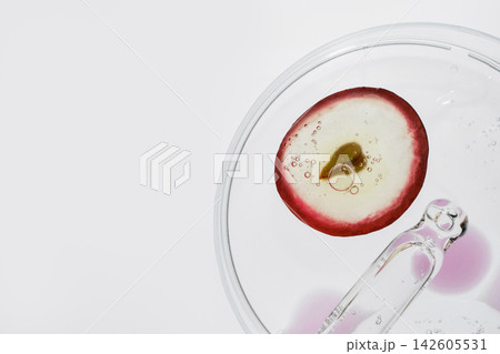 Grape half with liquid, bubbles and dropper in petri dish for skincare research 142605531