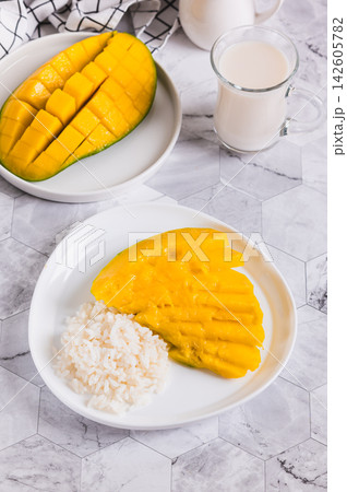 Trendy mango sticky rice dessert on a plate on the table vertical view 142605782