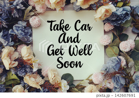 Take Care And Get Well Soon text with flower decoration on wooden background Take Care And Get Well Soon text with flower decoration on wooden background 142607691