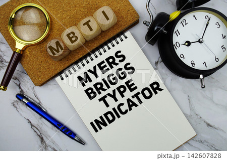 MBTI Myers Briggs Type Indicator text written on notepad with calculator and magnifying glass on marble background 142607828