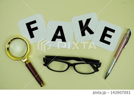 FAKE alphabet letters with magnifying glass, eye glasses and pen on yellow background FAKE alphabet letters with magnifying glass, eye glasses and pen on yellow background 142607881