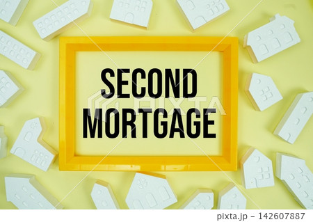 Second Mortgage text with house models on yellow background Second Mortgage text with house models on yellow background 142607887
