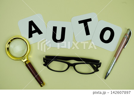 AUTO alphabet letters with magnifying glass, eye glasses and pen on yellow background AUTO alphabet letters with magnifying glass, eye glasses and pen on yellow background 142607897