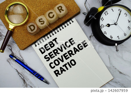 DSCR Debt Service Coverage Ratio text written on notepad with calculator and magnifying glass on marble background DSCR Debt Service Coverage Ratio text written on notepad with calculator and magnifying glass on marble background 142607959