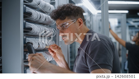 IT Technician Using Micro Brush and Vacuum to Clean Server Patch Cables IT Technician Using Micro Brush and Vacuum to Clean Server Patch Cables 142608501