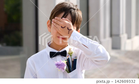Schoolboy Covering His Face with Hand-Drawn Closed Eyes, Back to School Emotions, September 1, School Stress, Humor and Childhood Creativity Schoolboy Covering His Face with Hand-Drawn Closed Eyes, Back to School Emotions, September 1, School Stress, Humor and Childhood Creativity 142609332