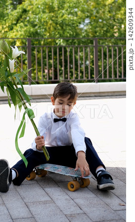 Schoolboy with Flowers and Skateboard on September 1, First Day of School, Back to School, Knowledge Day, Modern Student and School Life 142609344