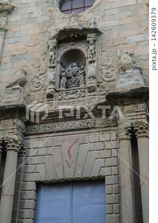 Weathered stone church entrance with ornate carvings and blue door 142609379