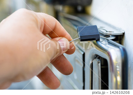 Hand installing a metal security lock handle on a delivery van door Hand installing a metal security lock handle on a delivery van door 142610208