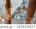 錆びたチェーンと老朽化した金属ポール 142610423