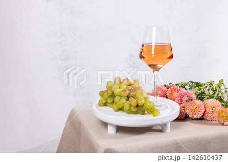 Rose wine glass with green grapes on table Rose wine glass with green grapes on table 142610437