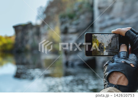 Photographer capturing stunning autumn landscape with smartphone 142610753