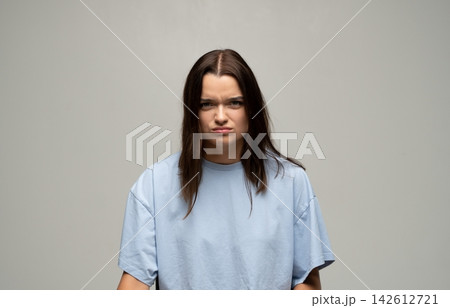 Young woman feeling frustration and displeasure, expressing annoyance with a frown on her face 142612721