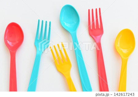 colorful spoon and fork isolated on white background, plastic cutlery for picnic 142617243