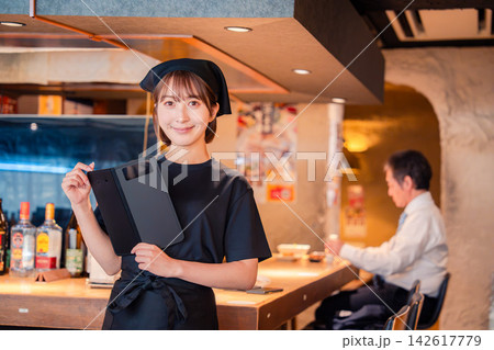 居酒屋で伝票を持つ若い女性スタッフ 居酒屋で伝票を持つ若い女性スタッフ 142617779