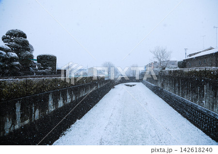 白く染まった用水路と雪が降り続く冬の静かな風景 白く染まった用水路と雪が降り続く冬の静かな風景 142618240