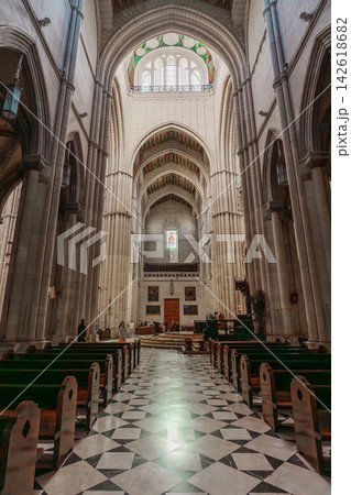 Wide view of the nave and side chapel of Almudena Cathedral with visitors walking Wide view of the nave and side chapel of Almudena Cathedral with visitors walking 142618682
