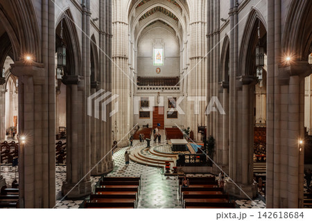 Wide view of the nave and side chapel of Almudena Cathedral with visitors walking Wide view of the nave and side chapel of Almudena Cathedral with visitors walking 142618684