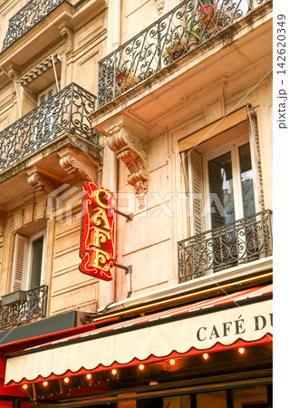 Paris cafe neon sign creating a vibrant focal point on a historic french building with balconies and shuttered windows Paris cafe neon sign creating a vibrant focal point on a historic french building with balconies and shuttered windows 142620349