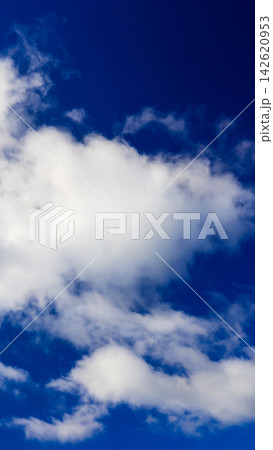 a large white cloud set against a deepening saturated blue sky a large white cloud set against a deepening saturated blue sky 142620953