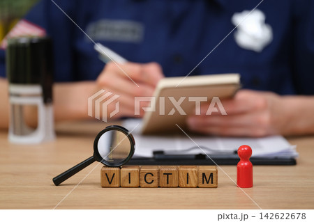 Focus on crime investigation with a magnifying glass and game pieces on a wooden table Focus on crime investigation with a magnifying glass and game pieces on a wooden table 142622678